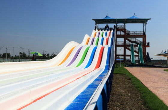 Toboggan aquatique multicolore à plusieurs voies pour parc aquatique | Toboggan de course à 4 voies sur tapis | Fabricant de toboggans arc-en-ciel en fibre de verre depuis 1994