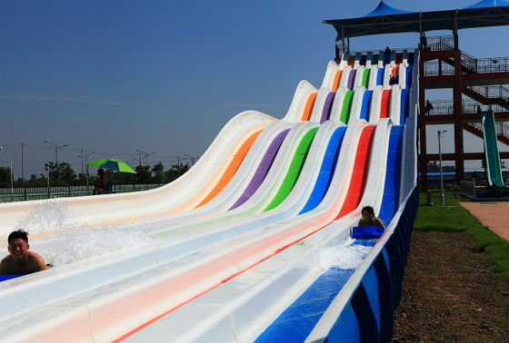 Toboggan aquatique multicolore à plusieurs voies pour parc aquatique | Toboggan de course à 4 voies sur tapis | Fabricant de toboggans arc-en-ciel en fibre de verre depuis 1994