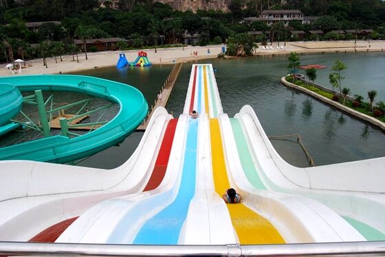 Toboggan aquatique multicolore à plusieurs voies pour parc aquatique | Toboggan de course à 4 voies sur tapis | Fabricant de toboggans arc-en-ciel en fibre de verre depuis 1994